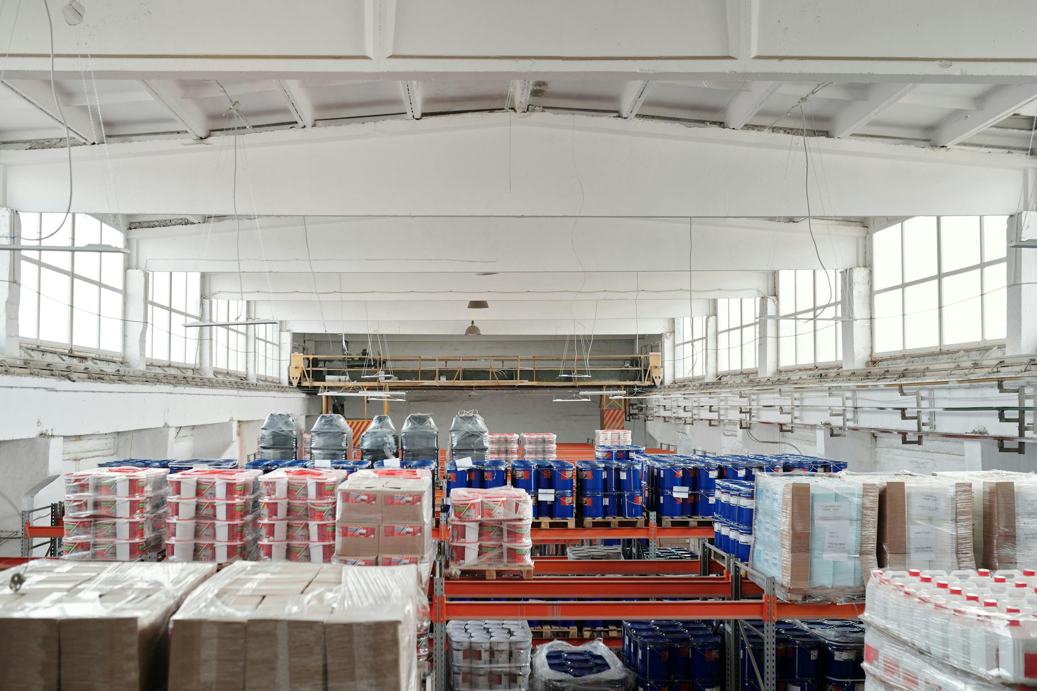 Spacious warehouse interior featuring organized shelves with various stacked pallets.